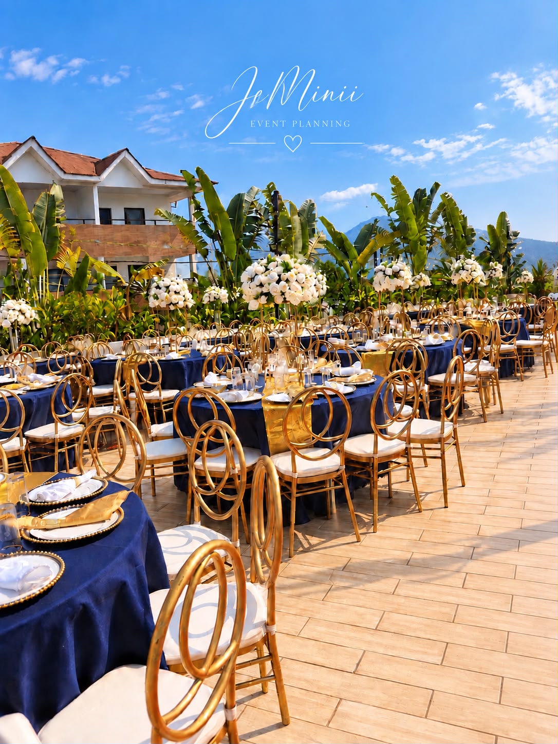 Outdoor wedding tables dressed in navy and gold beneath a bright blue sky, styled by Jeminii Event Styling in Freetown, Sierra Leone